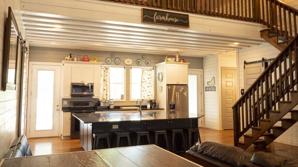 A spacious kitchen with a central island, wooden flooring, and a staircase leading to an upper level. - Farmhouse - located on the 18th Hole (Concan)