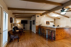 Relax in the living area with a sofa, armchairs, and a mounted TV.