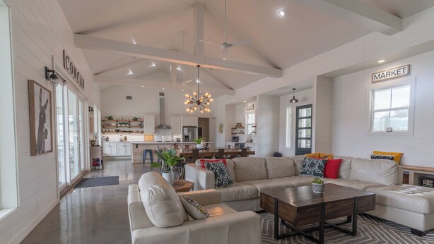 A spacious living area with a large sectional sofa, a coffee table, and a kitchen in the background. - Unique Vacation Home located in Concan near the golf course (Concan)
