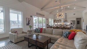 A spacious living room with a large sectional sofa, a coffee table, and a view of the kitchen and dining area. - Unique Vacation Home located in Concan near the golf course (Concan)