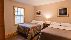 A bedroom with two beds, a window, and a nightstand with a lamp. - Frio Country Resort - Within walking distance to the Frio River! (Concan)
