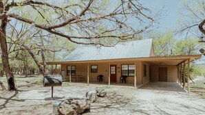 Una casa a un piano con un portico coperto, una cassetta delle lettere e un vialetto in pietra che conduce all'ingresso.