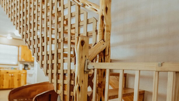 Una scala in legno con ringhiera e pavimento in legno.