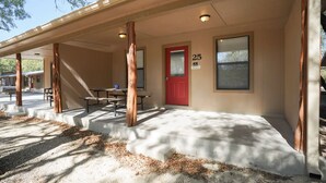 A covered outdoor area with concrete steps leading to a red door marked with the number 25. - Frio Country Resort - Within walking distance to the Frio River! (Concan)