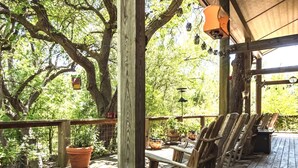 Eine Holzterrasse mit Sitzgelegenheiten und Blumentöpfen.