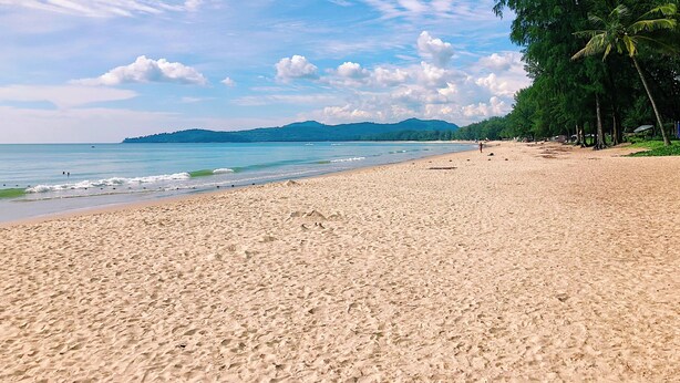 A beach with a sandy shore, calm sea, and distant hills. - Luxe 2br Pool Villa Walk to Bangtao Beach (Choeng Thale)
