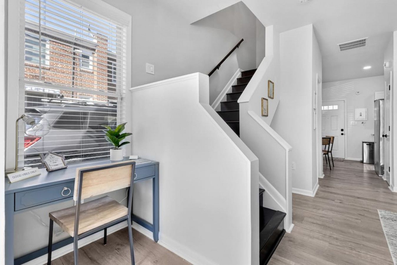 A modern interior with a desk, chair, and staircase.