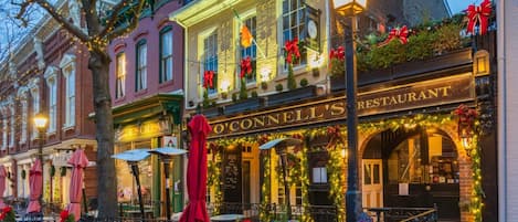 A restaurant with outdoor seating, a classic facade, and festive decorations.