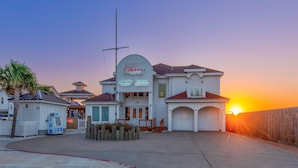 Ein Ufergrundstück mit einem Schild, das 'Rokono Yacht Club' zeigt, einer Anlegestelle und einem Sonnenuntergang im Hintergrund.