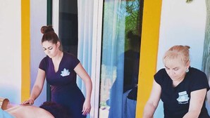 Une salle de massage équipée de deux tables de massage, chacune étant occupée par un client et un thérapeute.