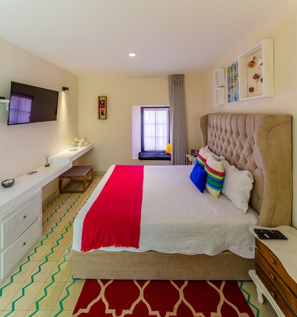 A bedroom with a bed, bedside table, TV, and a window with curtains. - Palpatio Hotel Boutique (Guadalajara)