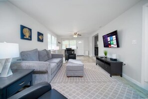 Relax in this stylish living room with a sofa, ottoman, and flat-screen TV.