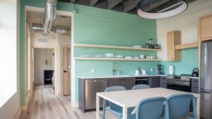 A modern kitchen with a teal brick backsplash, stainless steel appliances, and a central island with seating. - Flat 304 Front and Union (Traverse City)