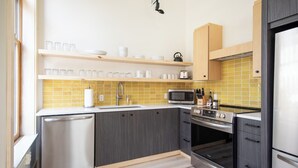 Une cuisine moderne avec des meubles de couleur grise, un lave-vaisselle, un four à micro-ondes, un four et un réfrigérateur.