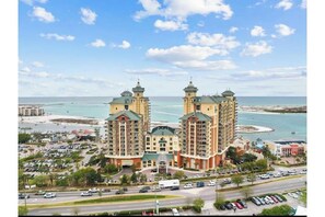 Un hôtel doté de deux tours imposantes, offrant une vue sur la plage et disposant d’un parking.