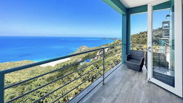 Uma varanda com vista desobstruída para o oceano e as colinas.