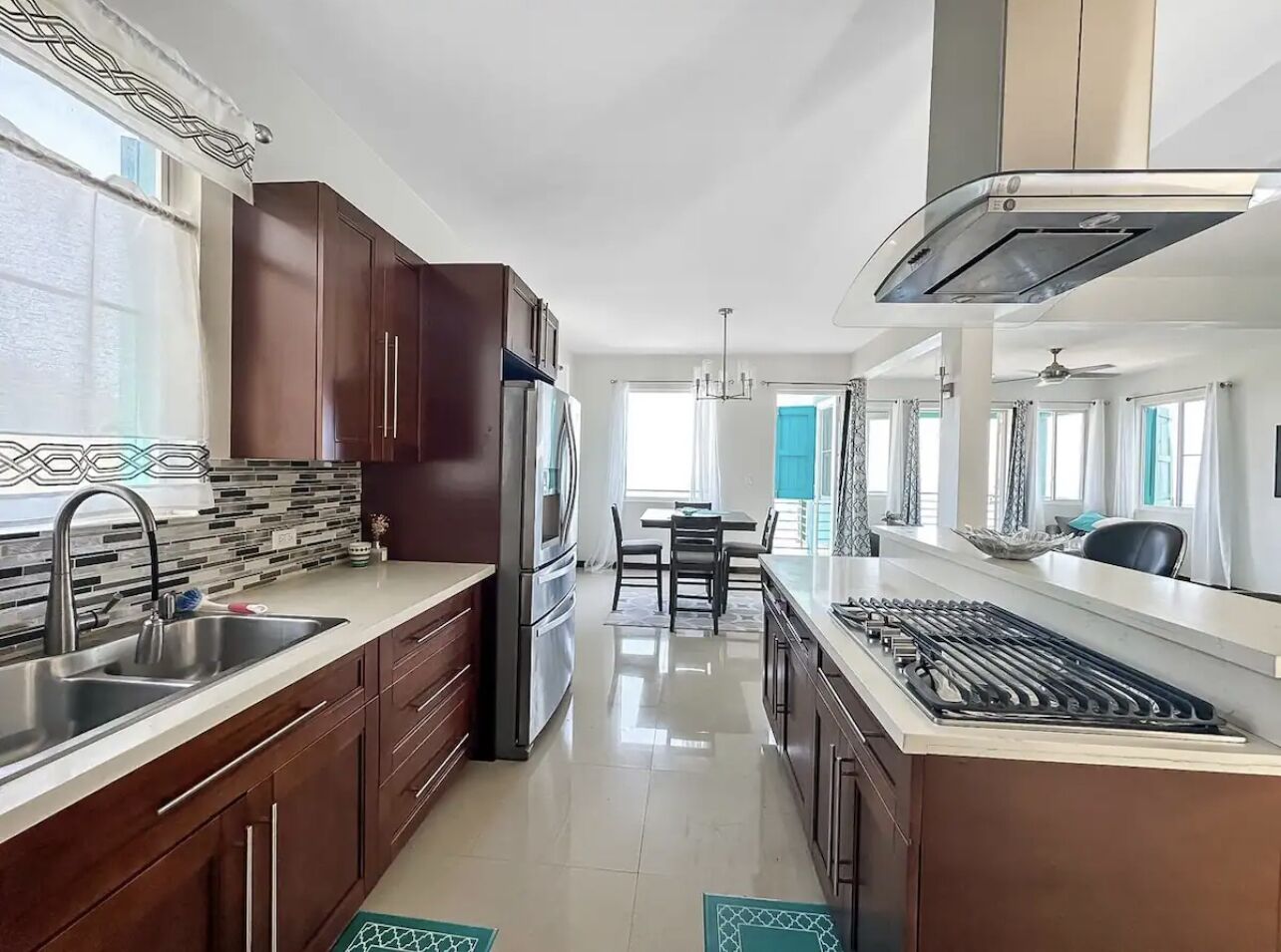 A modern kitchen with dark wooden cabinets, stainless steel appliances, and a central island.