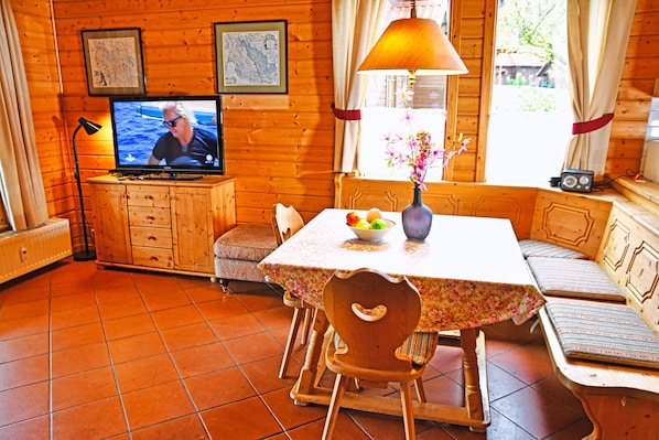 Cozy cabin interior with a dining table, TV, and comfortable seating area.