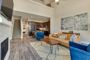 Un salon moderne avec une cheminée, un canapé, une table basse et un coin repas.