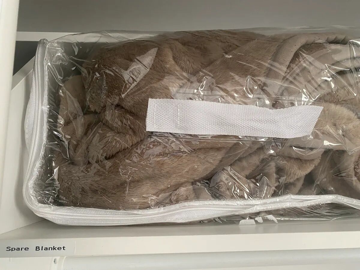 Un sac en plastique contenant un objet brun, qui pourrait être un animal de compagnie, et sur lequel est apposée une étiquette.