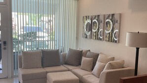 A modern living room with a sectional sofa, a glass coffee table, and a floor lamp. - "Stylish and beautiful Condo located in Sosua" (sosua)