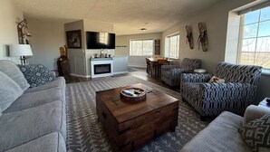 A living room with a fireplace, sofa, coffee table, and a TV mounted on the wall. - Powderhorn Slopeside 3 Bedroom / 3.5 Bath Condo Next to Ski Lift (Mesa)