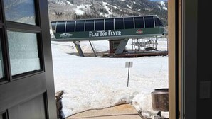 A doorway leading to a snowy outdoor area with a flat top flyer sign, a metal grill, and a clear sky. - Powderhorn Slopeside 3 Bedroom / 3.5 Bath Condo Next to Ski Lift (Mesa)