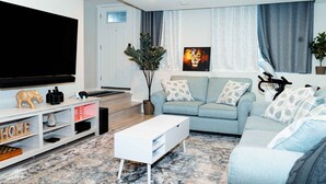 Ein modernes Wohnzimmer mit einem Flachbildfernseher, einer Couch, einem Couchtisch und einer dekorativen Elefantfigur.