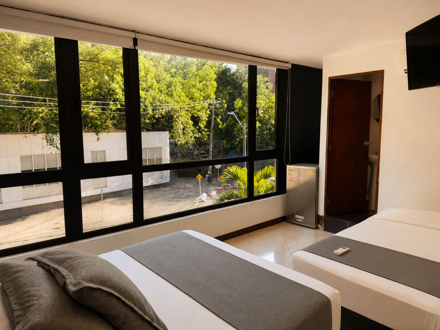 Un dormitorio con dos camas, un ventanal y vista al exterior.