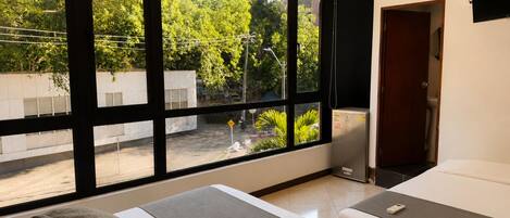 Un dormitorio con dos camas, un ventanal y vista al exterior.