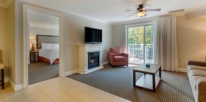 Ein Hotelzimmer mit Kamin, Fernseher, einer Couch und einem Sessel.