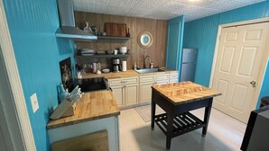A compact kitchen with a sink, stove, and wooden cabinets. -     Private Tropical Oasis in Coastal Paradise
W fenced yard. (Clearwater)