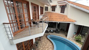 A residential property with a swimming pool, a balcony with a railing, and a tiled patio area. - Hot Springs pool in historic Baños del Inca, 10 min. from Cajamarca, sleeps 6 (Cajamarca)