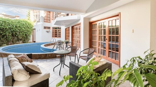 A pool area with a circular pool, outdoor seating, and a staircase leading to an upper level. - Hot Springs pool in historic Baños del Inca, 10 min. from Cajamarca, sleeps 6 (Cajamarca)