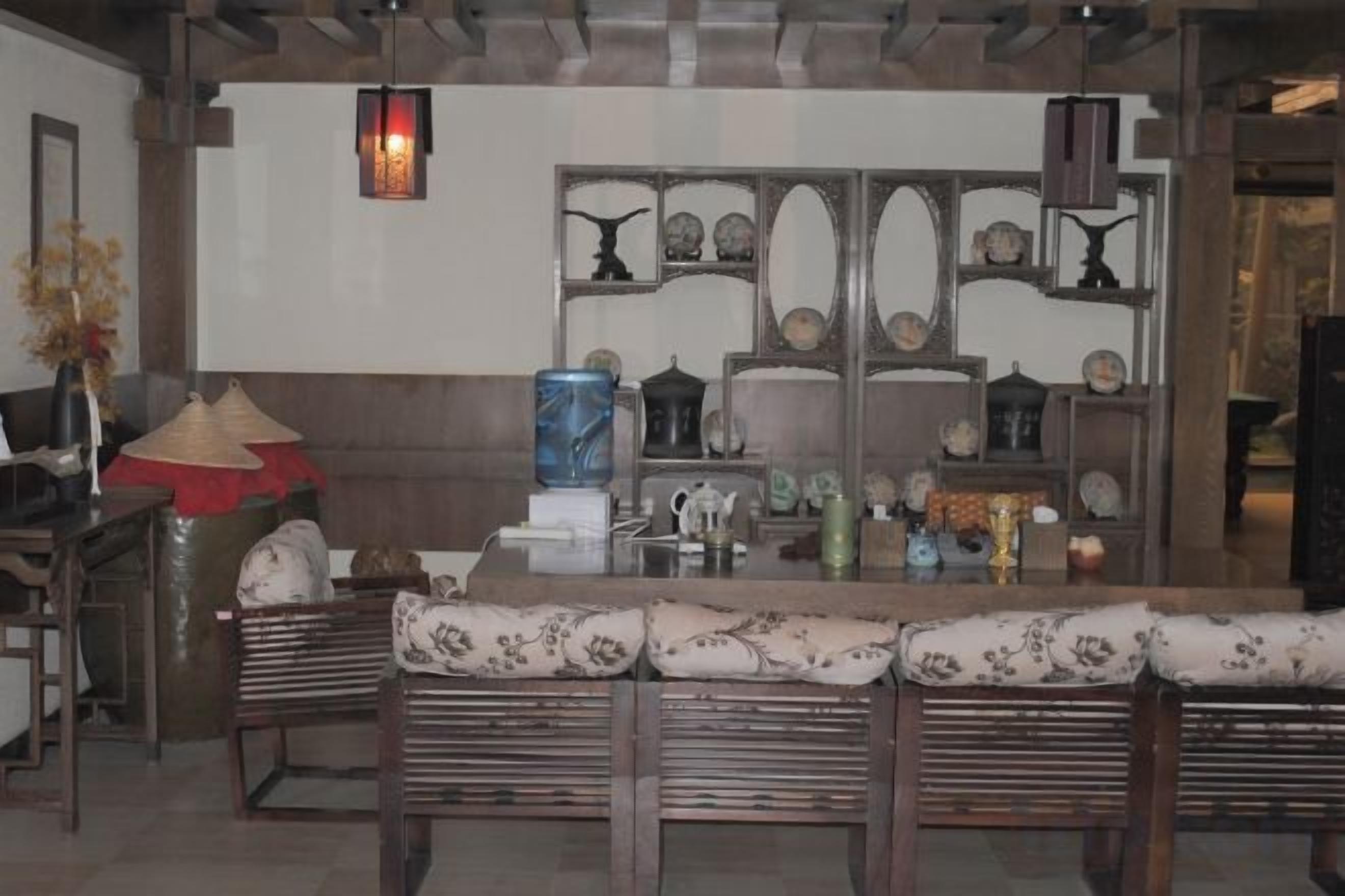 Un interior tradicional con una larga mesa de madera, bancos acolchados y elementos decorativos en la pared.