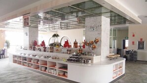 Een moderne keuken met een centraal kookeiland, voorzien van diverse kookgerei en apparaten.