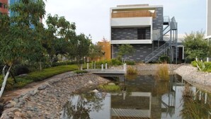 Een modern gebouw met een reflecterend waterkunstwerk ervoor.