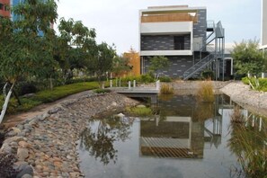A modern building with a reflective water feature in front. - Chuntian Wenti Huiguan Hotel (Kunming)