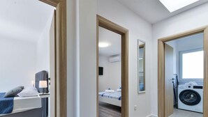 Een modern appartement met een slaapkamer, een badkamer en een wasruimte.