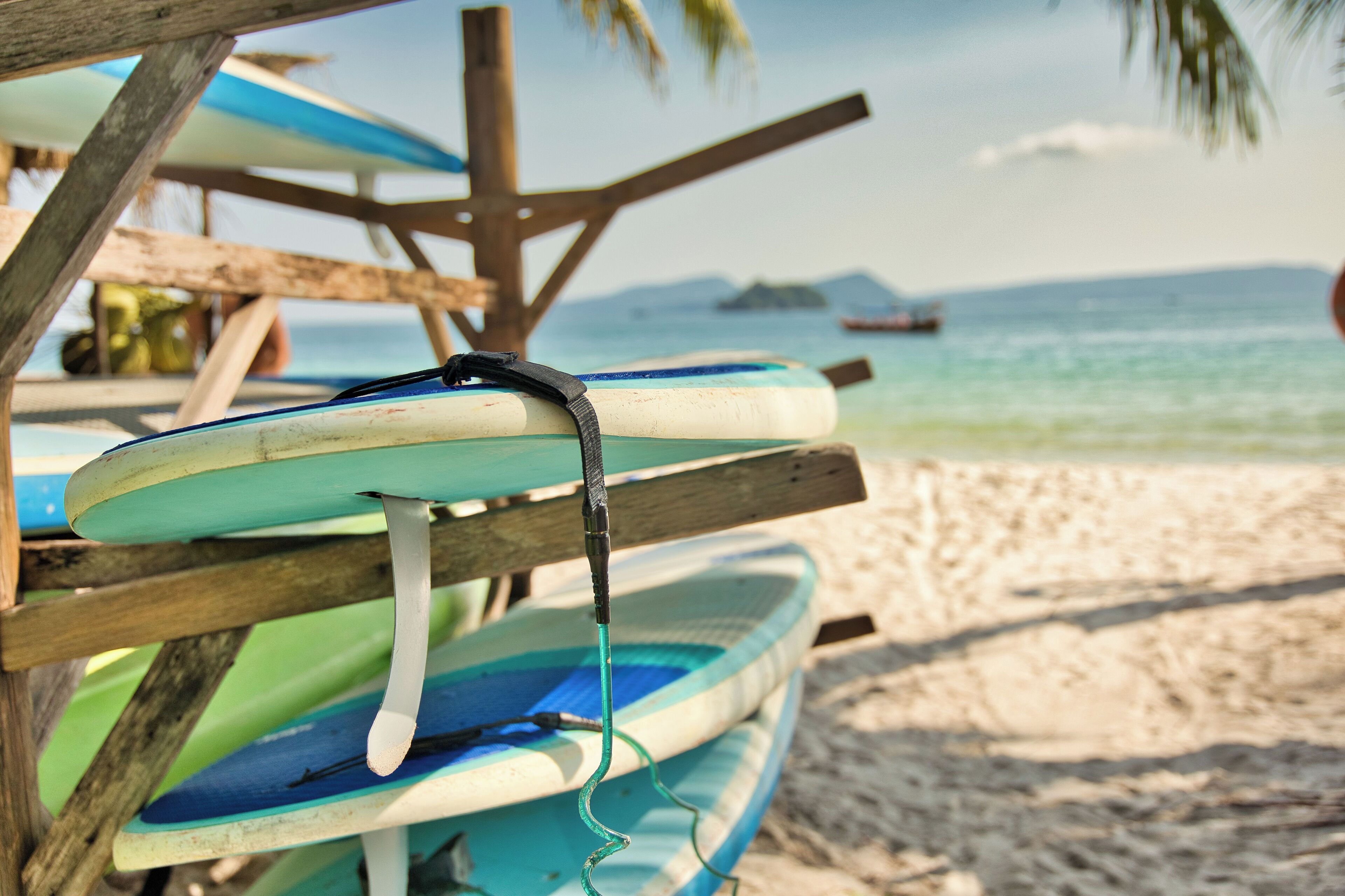A wooden structure with surfboards leaning against it on a beach.
