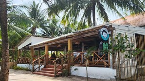 A wooden structure with a covered seating area and a signboard.