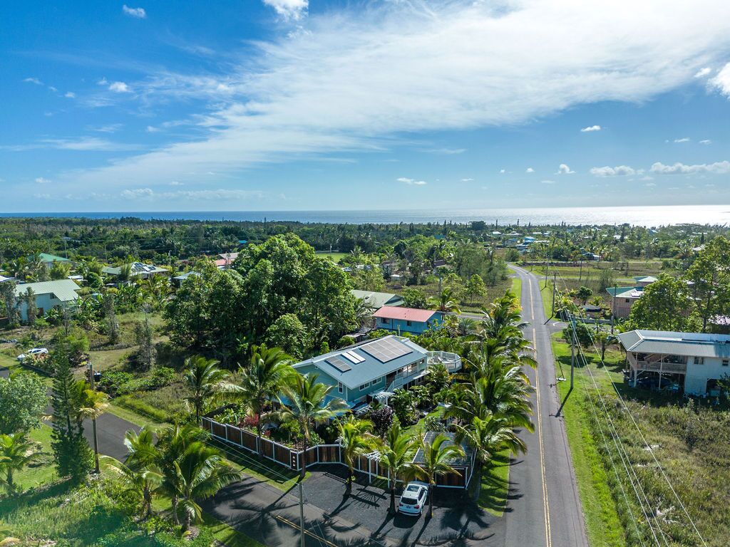 Vista aérea de una zona residencial con casas, una carretera y una masa de agua al fondo.