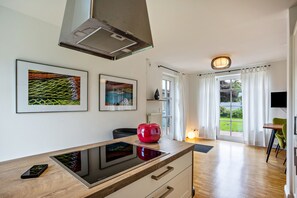 Una cucina moderna con piano cottura integrato, un elemento decorativo rosso e opere d'arte alle pareti.