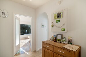 A hallway with a wooden cabinet, a clock, and a bulletin board with various notices. - Bibernest Holiday Home with Private Terrace, AlbCard Partner (Münsingen)