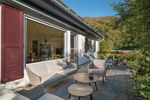 An outdoor patio with a sofa, chairs, and tables. - Bibernest Holiday Home with Private Terrace, AlbCard Partner (Münsingen)