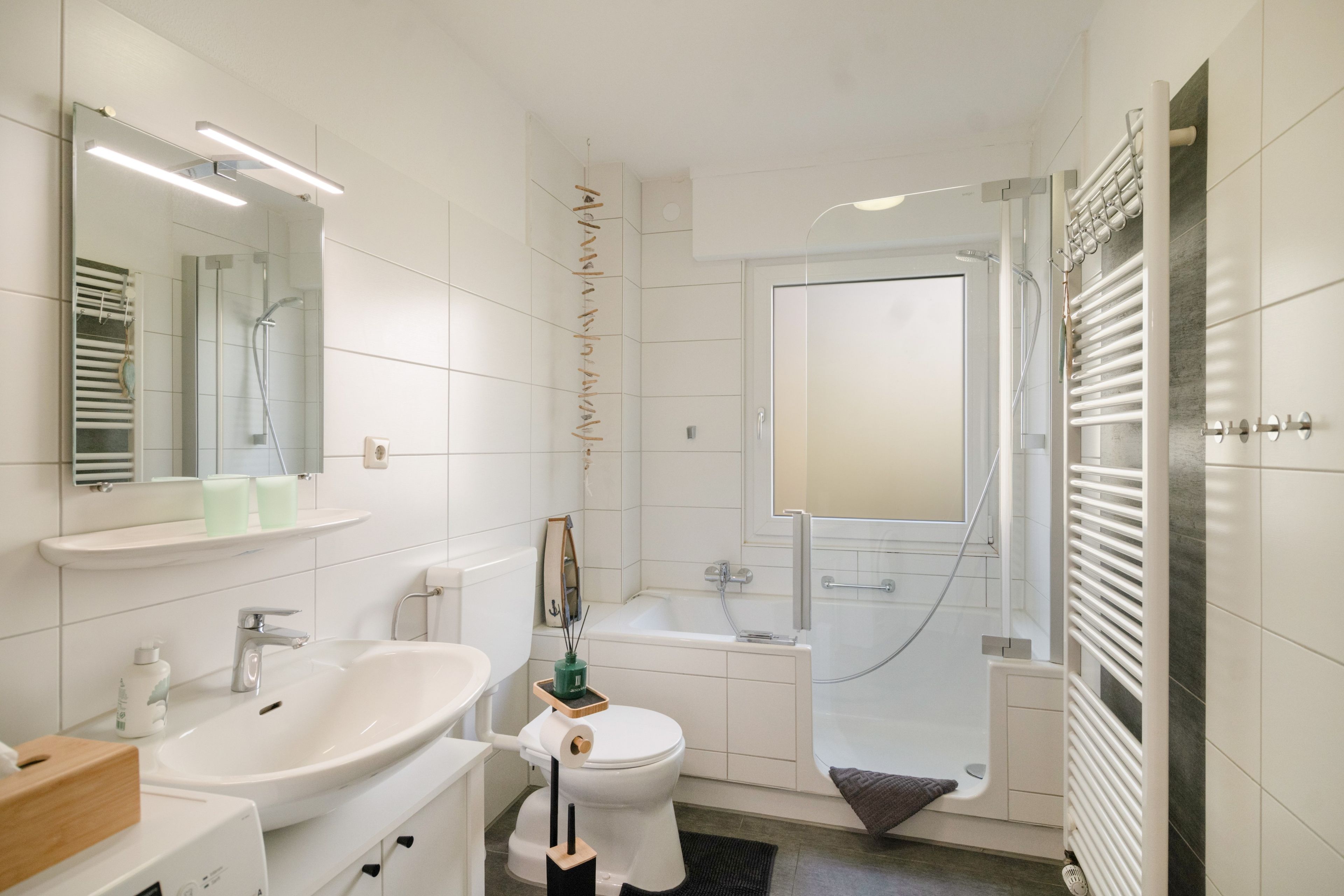 Ein modernes Badezimmer mit Waschbecken, Toilette, Badewanne und Dusche.