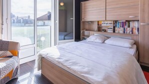 Ein Schlafzimmer mit einem großen Bett, einem Holzschrank und einem Bücherregal.