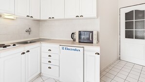 Una cocina moderna con armarios blancos, un microondas y un lavamanos.
