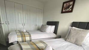 Een hotelkamer met twee bedden, een kledingkast en een lijst aan de muur.