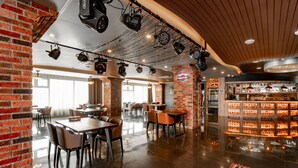 Un restaurante con paredes de ladrillo, techo de madera y mesas con sillas.